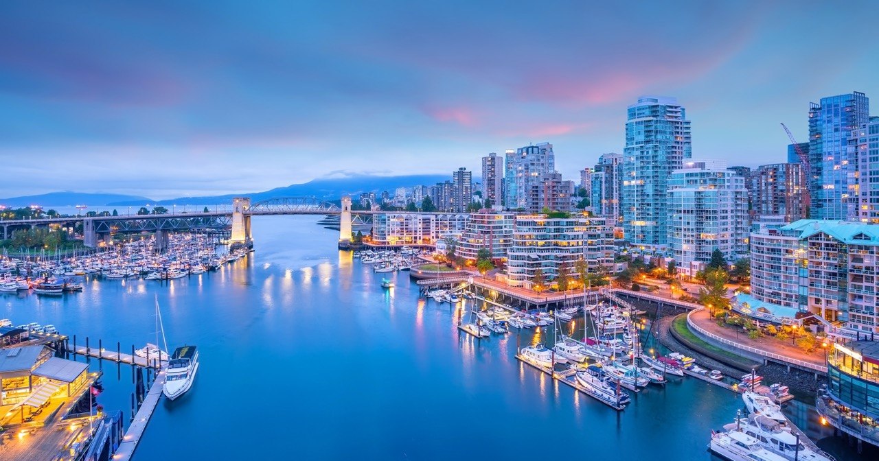 Vancouver skyline with North Shore mountains reflected in English Bay waters at golden hour